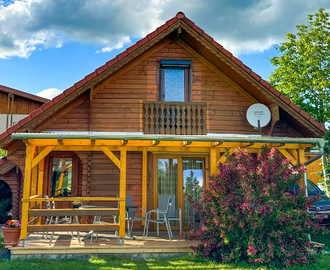 Blick über grünem Rasen auf Blockhaus
